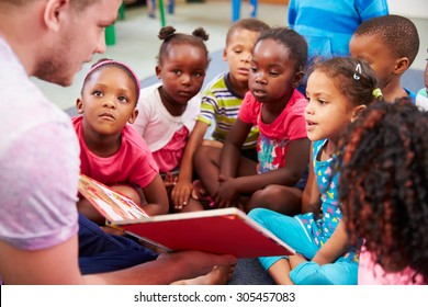 Volunteer teacher reading to a class of preschool kids