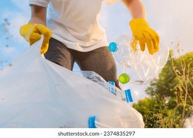 Volunteer teenage boys are holding garbage bags and Collecting plastic bottle waste at public parks for recycling, Reuse, and waste management concepts. - Powered by Shutterstock