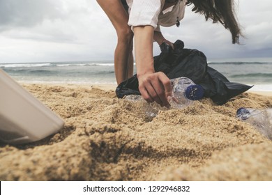 Volunteer woman collecting trash on the beach. Trash-free seas concept. Single-use plastic is a human addiction that is destroying our planet