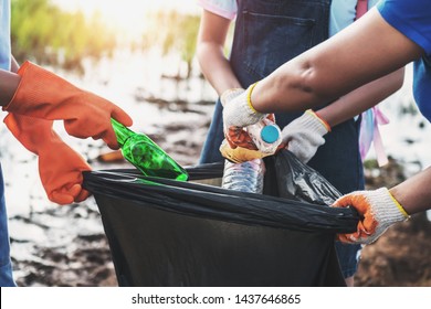 Volunteer Woman Picking Up Garbage Plastic For Cleaning At River Park