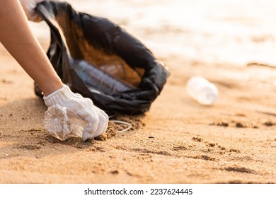 Volunteer woman picking plastic bottle into trash plastic bag black for cleaning the beach, female clean up garbage, Ecology concept and World Environment Day, Save earth concept - Powered by Shutterstock