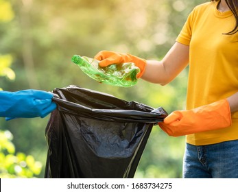 Volunteer women collect plastic water bottles in the park area, From people who refuse to throw in the trash into bag for recycling - Powered by Shutterstock