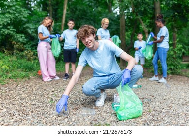 Volunteering, Charity, Cleaning, People And Ecology Concept - Group Of Happy Volunteers With Garbage Bags Cleaning Area In Park