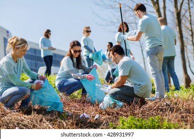 volunteering, charity, cleaning, people and ecology concept - group of happy volunteers with garbage bags cleaning area in park - Shutterstock ID 428931997