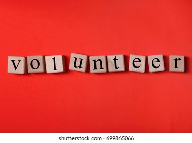 Volunteering concept. Wooden cubes on color background - Shutterstock ID 699865066