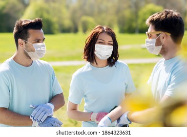 Volunteering, Health And Ecology Concept - Group Of Volunteers Wearing Face Protective Medical Masks For Protection From Virus Disease In Park