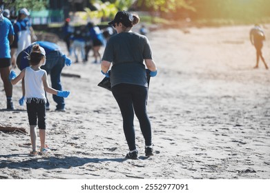 Volunteers of all ages gather on beach to clean up litter and promote environmental awareness. - Powered by Shutterstock