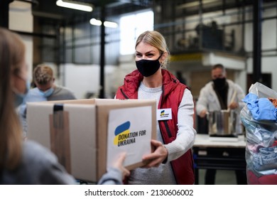 Volunteers collecting donations for the needs of Ukrainian migrants, humanitarian aid concept. - Shutterstock ID 2130606002