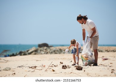 Volunteers father and little daughter cleaning beach from trash left by tourists - Powered by Shutterstock