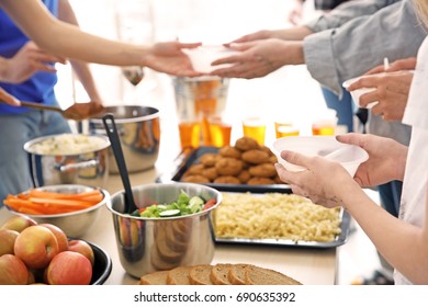 Volunteers giving food to poor people. Poverty concept - Shutterstock ID 690635392