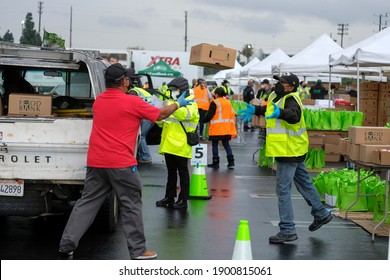 Volunteers Load Food Into The Trunk Of A Vehicle During A Drive Thru Food Distribution By The Los Angeles Regional Food Bank At Exposition Park On Saturday, Jan. 23, 2021, In Los Angeles. 