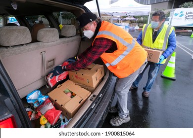 Volunteers Load Food Into The Trunk Of A Vehicle During A Drive Thru Food Distribution By The Los Angeles Regional Food Bank At Exposition Park On Saturday, Jan. 23, 2021, In Los Angeles.