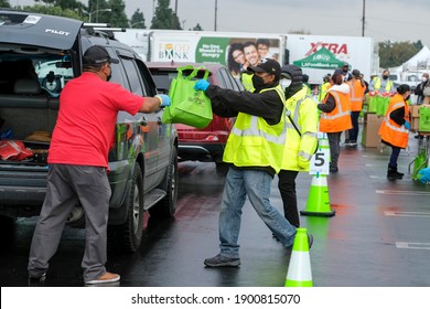 Volunteers Load Food Into The Trunk Of A Vehicle During A Drive Thru Food Distribution By The Los Angeles Regional Food Bank At Exposition Park On Saturday, Jan. 23, 2021, In Los Angeles. 