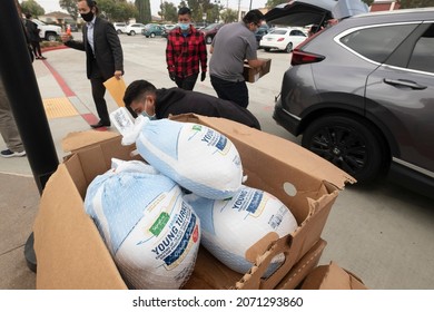 Volunteers load turkeys into the trunk of vehicles during a turkeys distribution event in Rosemead, Calif. Monday, Nov. 8, 2021.