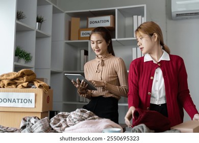 Volunteers Organizing Clothing Donations in Community Center for Charity and Support - Powered by Shutterstock