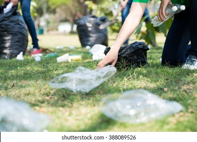 Volunteers Picking Up Trash On A Meadow