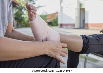 Volunteers Are Provided To Patient Ankle Wrap Elastic Bandage, With Patient Ankle Injury.