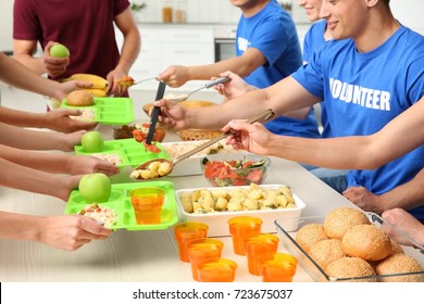 Volunteers Serving Food For Homeless People Indoors