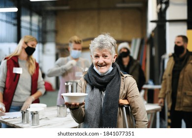 Volunteers Serving Hot Soup For Homeless In Community Charity Donation Center, Coronavirus Concept.