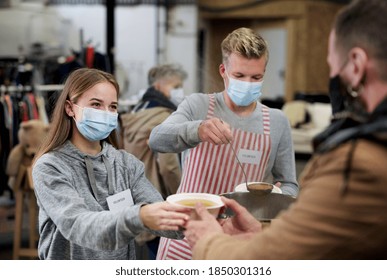 Volunteers Serving Hot Soup For Homeless In Community Charity Donation Center, Coronavirus Concept.