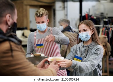 Volunteers serving hot soup for Ukrainian migrants in refugee centre, Russian conflict concept. - Shutterstock ID 2130605924