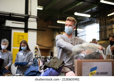 Volunteers sorting out donated clothes for the needs of Ukrainian migrants, humanitarian aid concept. - Powered by Shutterstock