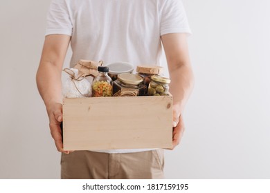 Volunteers Taking Food Out Of Donation Box On Table, Closeup