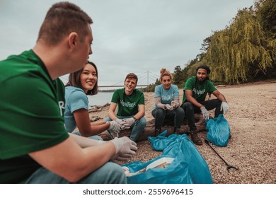 Volunteers wearing gloves and t-shirts are collecting trash on a riverbank, working together for environmental conservation - Powered by Shutterstock