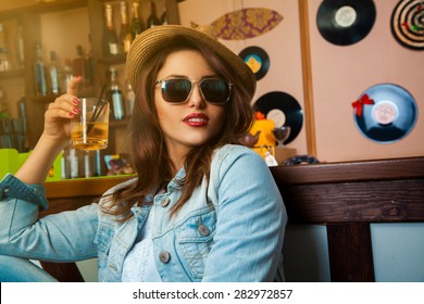 voluptuous young fashionable woman drink cocktail at bar. horizontal photo