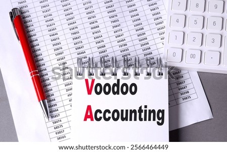 Voodoo accounting text on notepad with financial data sheets, a red pen, and a calculator on a desk .
