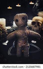 Voodoo Doll With Pins And Dried Flowers On Table Indoors