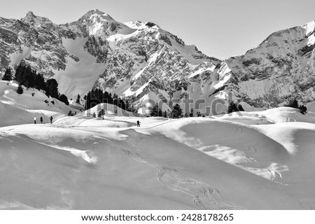VORARLBERG, AUSTRIA. December 20, 2021.High-resolution horizontal shots. An Austrian mountain scenic Alps, with snow-covered peaks against a dark sky, showing winter's quiet beauty in black and white.