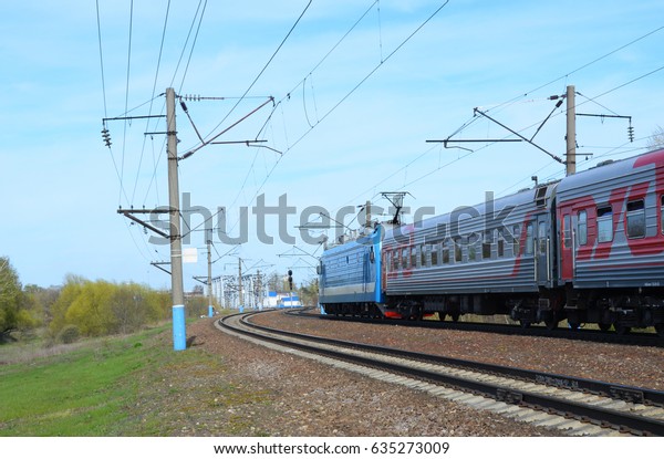 VORONEZH - APRIL 27: Russian Railways intercity\
train passes electrified railway lines in Voronezh on April 27,\
2017. Electric locomotive EP1M tows passenger cars with Russian\
Railways symbols,\
No.2.