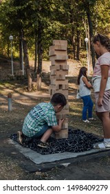 Voronezh, Russia September 5, 2019: Kids Playing In The Park Playing Jenga. Play Jung With A Very Large Wooden Blocks Outdoor Games For Children.