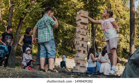 Voronezh, Russia September 5, 2019: Kids Playing In The Park Playing Jenga. Play Jung With A Very Large Wooden Blocks Outdoor Games For Children.