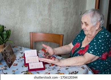 Voronezh/Russia - April 2020: Participant With Orders And Medals On May 9 At The Home.  Portrait Of A Woman-veteran Of The Second World War In Medals In The Interior Of The House