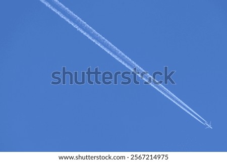Vortex smoke trail from a low flying jet aircraft bisecting a beautiful blue sky
