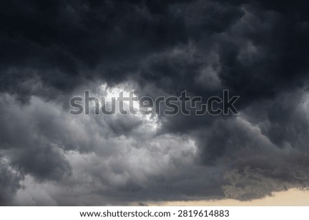 Vortex of turbulent dark storm clouds with central light patch