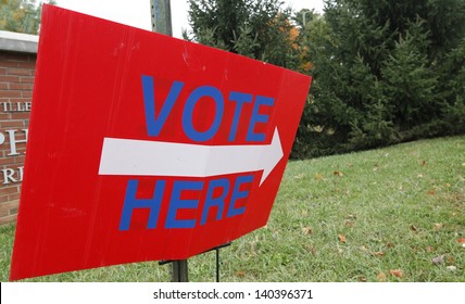 A Vote Here Sign Outside A Voting Station.