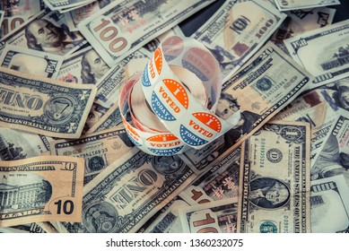 I vote Today stickers on a pile of American dollar bills, political election concept of economy and democratic elections in the USA. - Shutterstock ID 1360232075