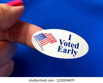 I Voted Early Sticker On A Woman’s Finger With Blue Background