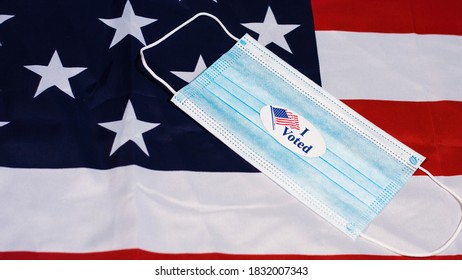 I Voted Sticker On Face Mask On Usa Flag. Presidential Elections Concept.