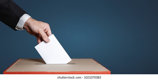 Voter Holds Envelope In Hand Above Vote Ballot On Blue Background. Freedom Democracy Concept