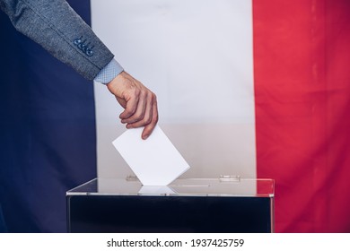 Voter Holds Envelope In Hand Above Ballot Box.