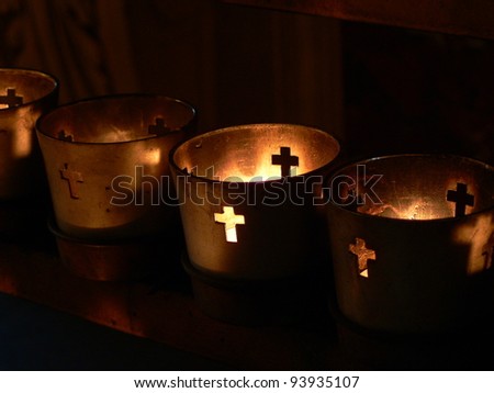 Votive candles burning in a darkened cathedral.