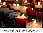 Votive prayer candles inside a catholic church on a candle rack