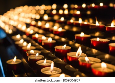 Votive Prayer Candles Inside A Catholic Church On A Candle Rack