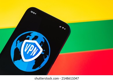 VPN in Lithuania. Secure and safe internet concept. Privacy. Hand with mobile phone and VPN application. Flag and laptop on the background photo