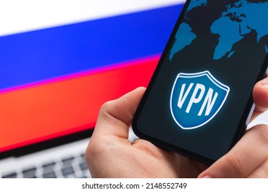 VPN In Russia. Secure And Privacy Internet. Blocked Websites. Hand With Mobile Phone And VPN Application. Flag And Laptop On The Background Photo