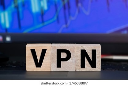 VPN Virtual Private Network written on a wooden cube in front of a laptop